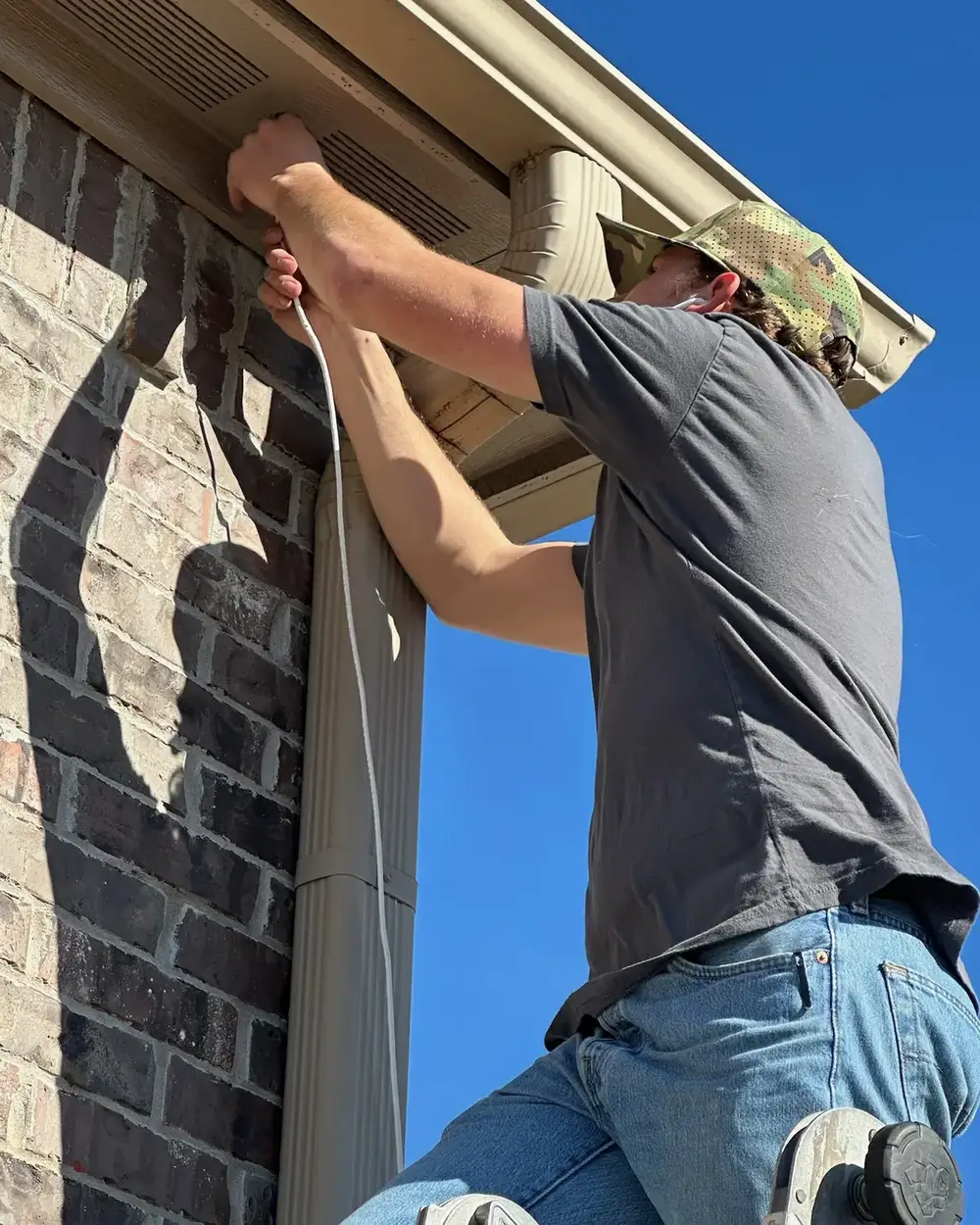 Technician installing a camera under the eave of a home