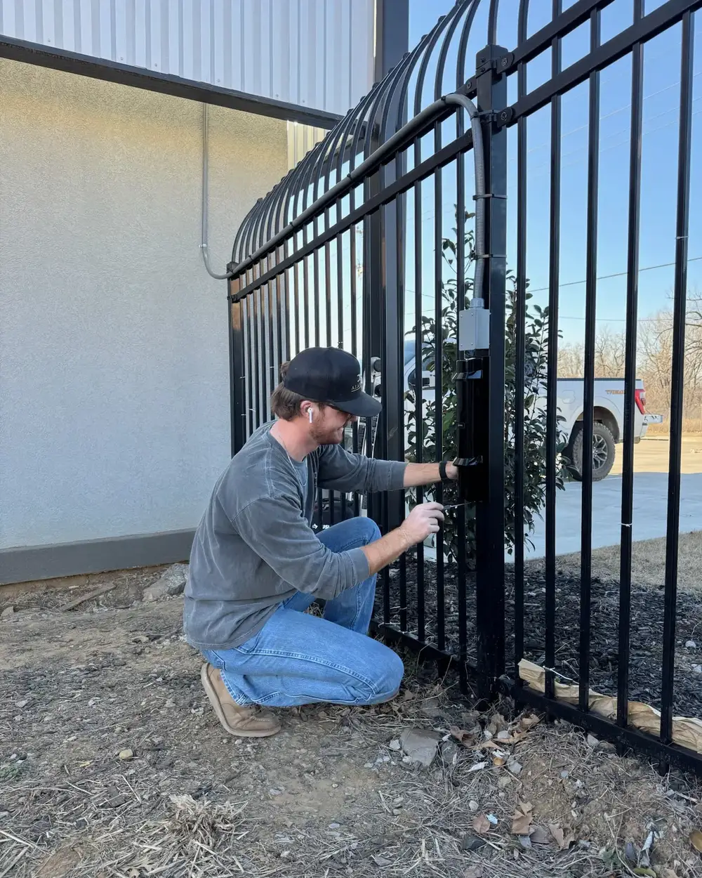 Tulsa Lock & Key technician wiring an access control reader at an iron gate